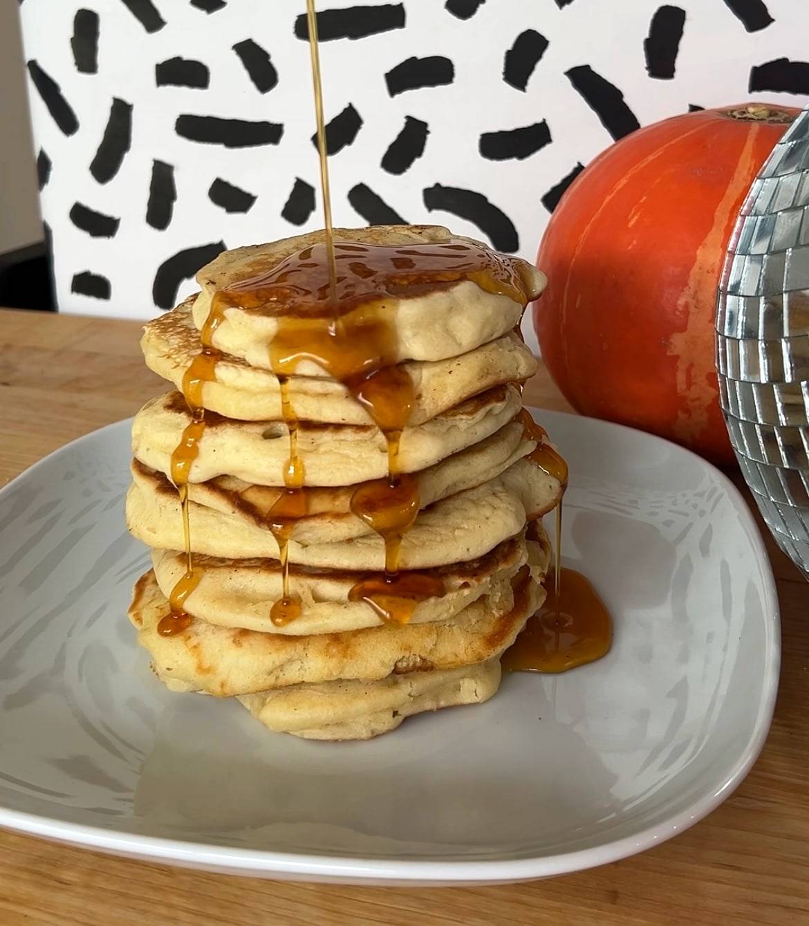 Pancake stack dripping with syrup next to a disco ball
