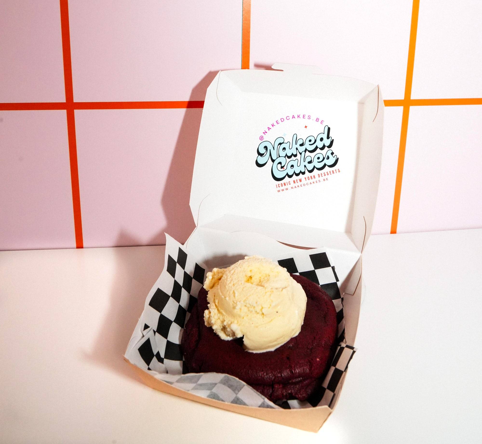 Red velvet cake with a scoop of vanilla ice cream in a Naked Cakes box