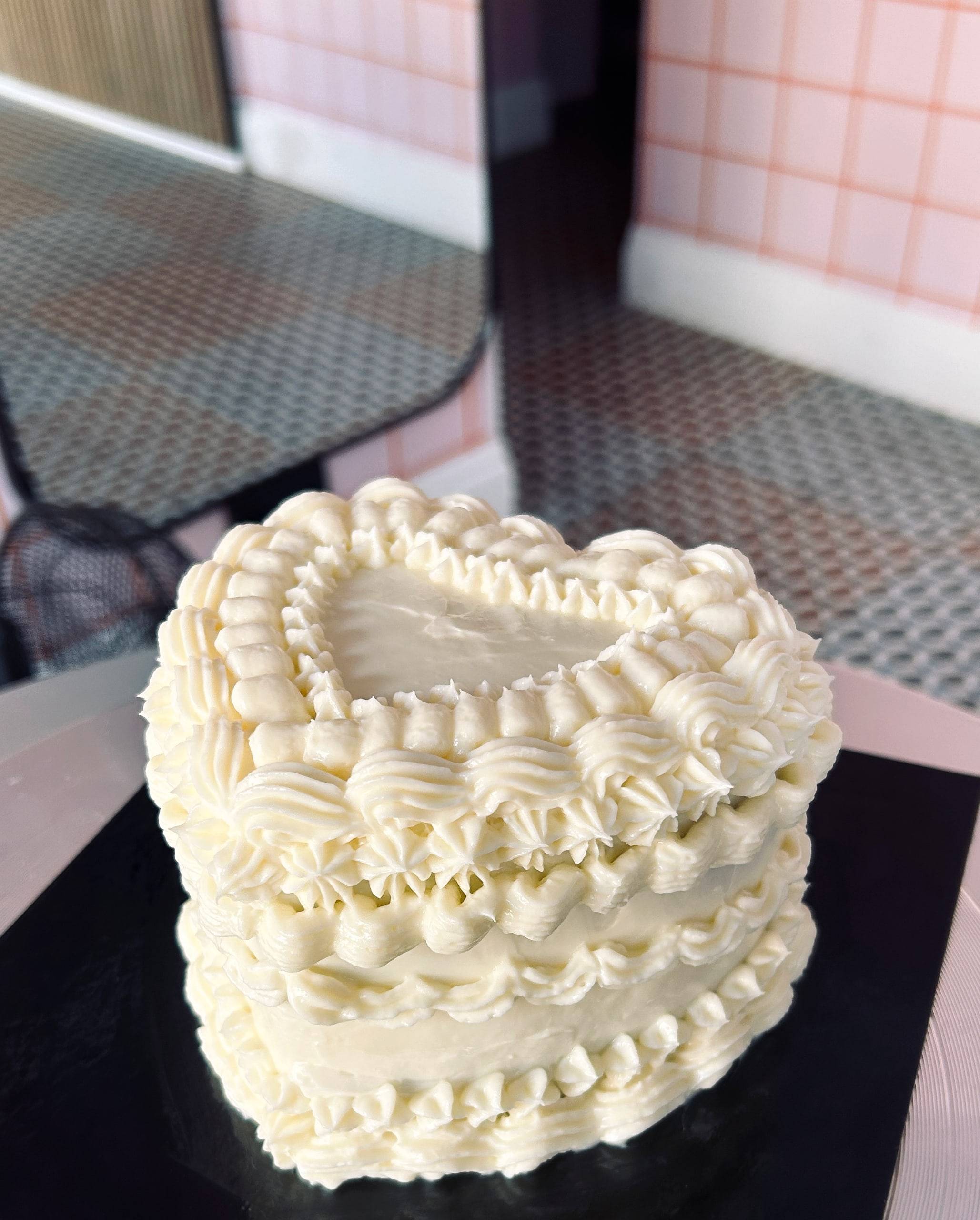 White heart cake covered in vintage piped frosting